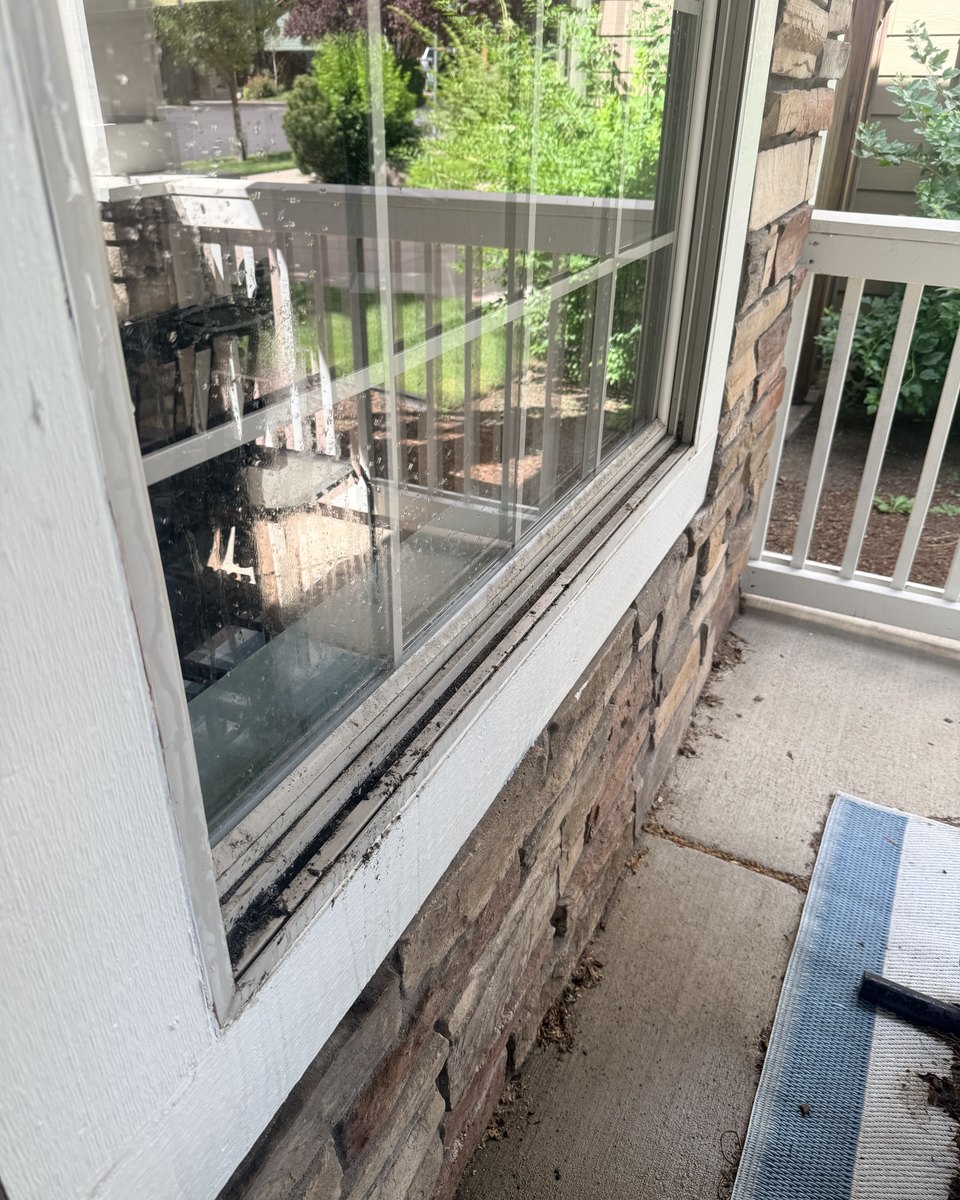 Residential window sill before cleaning, dirt packed in the track